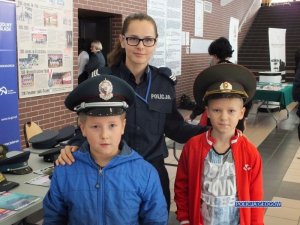 Dzieci w policyjnych czapkach wraz z policjantką