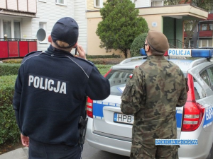 Policjant i żołnierz dzwonią do osoby objętej kwarantanną