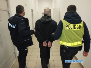 Policjanci prowadzą zatrzymanego