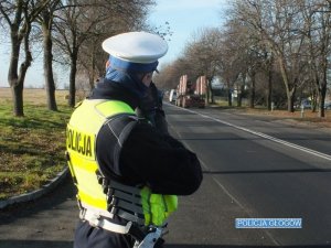 Policjant dokonuje pomiaru prędkości pojazdu na drodze