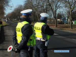 POloicjanci ruchu drogowego na trasie w trakcie pomiaru prędkości