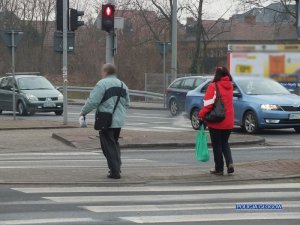 Piesi przechodzą przez ulicę na oznakowanym przejściu