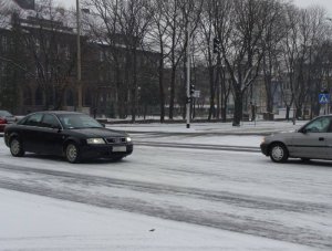 Pojazdy  na ośnieżonej ulicy w mieście