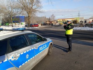 Umundurowany policjan ruchu drogowego mierzy pomiar prędkości na drodze