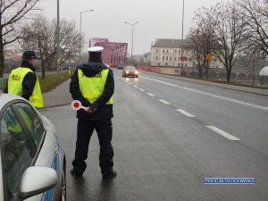 Policjanci  z Ruchu Drogowego w umundurowaniu prowadzą kontrolę na drodze